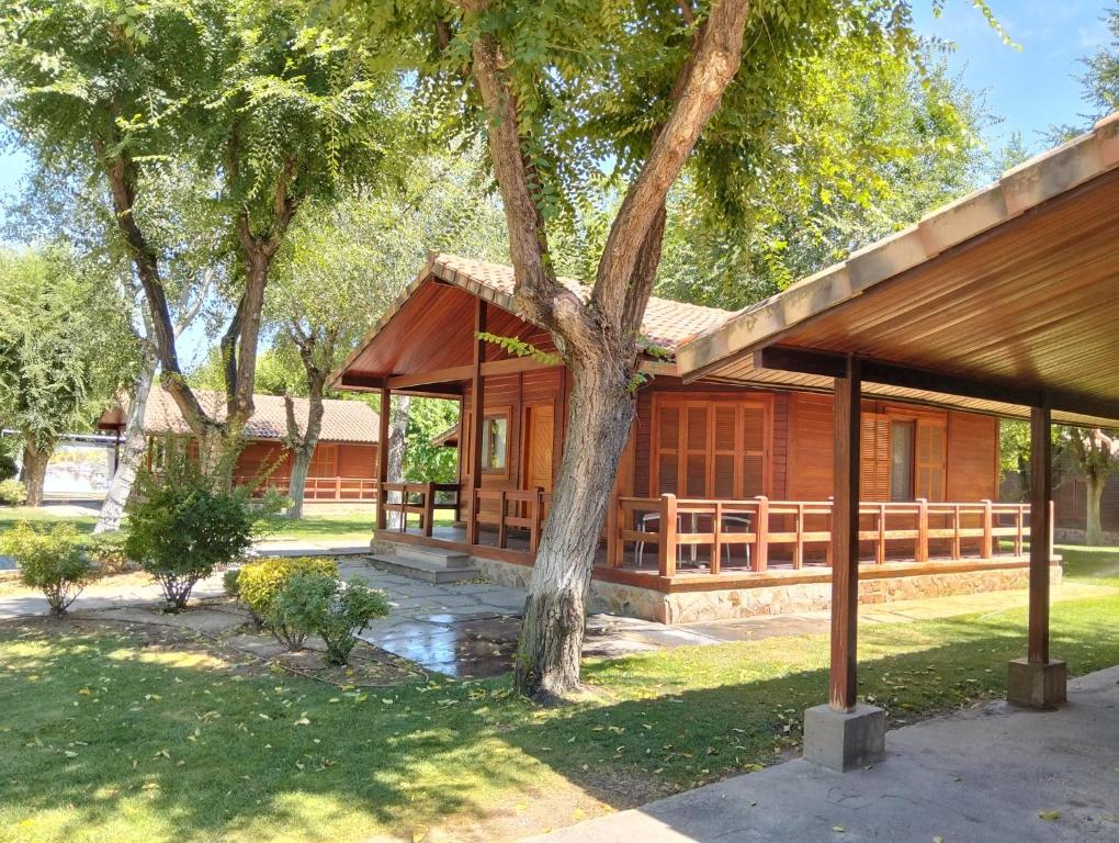 a building with a pavilion in a park with trees at Complejo La Cigüeña in Arganda del Rey