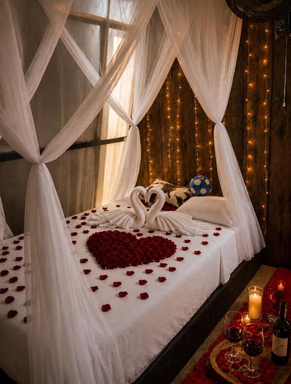 ein Schlafzimmer mit einem Bett mit zwei Schwänen aus Herzen in der Unterkunft Amazon Oasis in Leticia