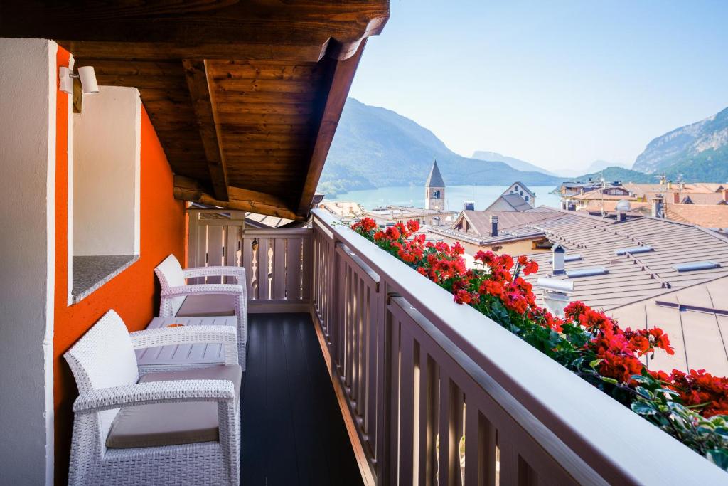 a balcony with chairs and flowers on a building at Residenza Garibaldi - Cirmolo in Molveno