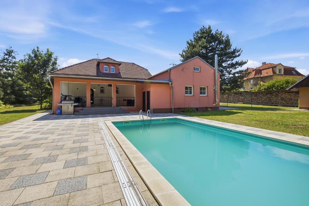 a swimming pool in front of a house at Vila v Lahošti in Teplice
