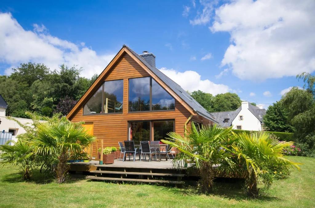 a wooden house with a large glass facade at Chambres à l'écrin de bois in Guerlédan