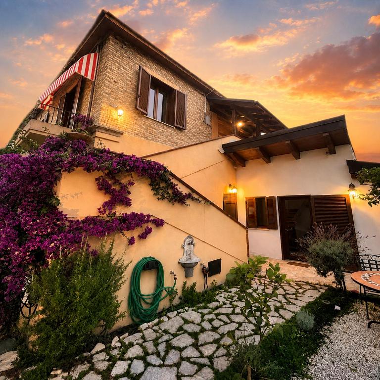 a building with purple flowers on the side of it at Casa Drema - Villa al mare con terrazza in Pescara