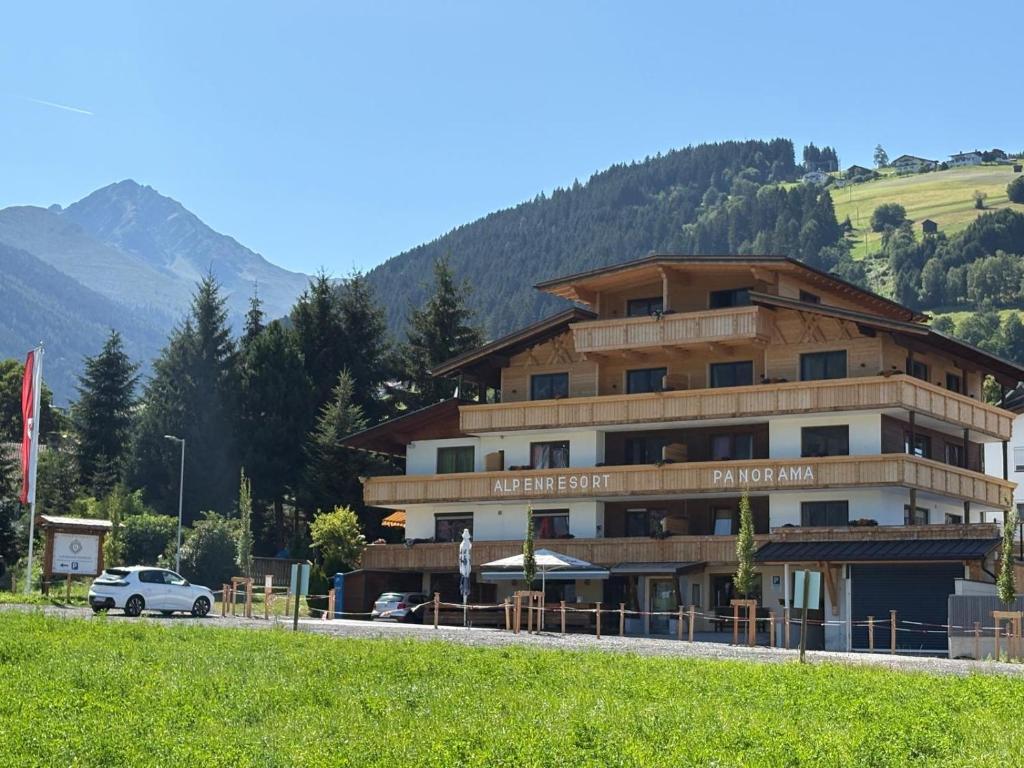 a building with a car parked in front of it at Alpenresort Panorama in Oberperfuss