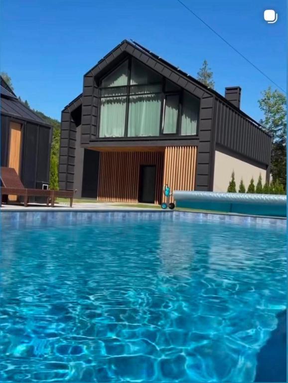 a house with a swimming pool in front of a house at Goldhill villa in Yaremche