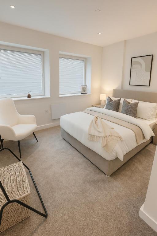 a white bedroom with a large bed and a chair at Copper Suite - 2Bed Elegance - Parking in Liverpool