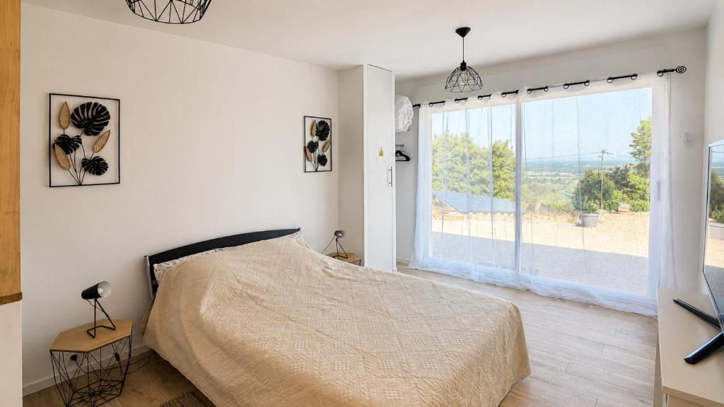 a bedroom with a bed and a large window at Beau Regard in Tournus