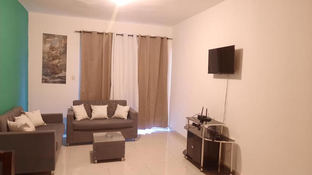 a living room with a couch and a flat screen tv at condominio Crismairy in Bayahibe