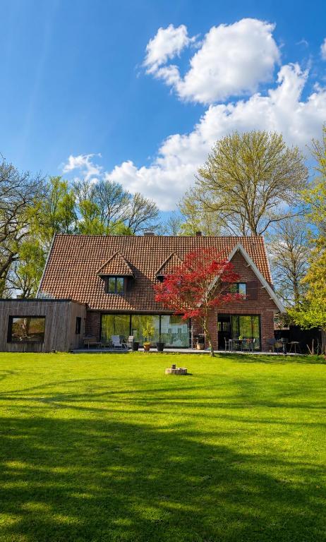 a large house with a green lawn in front of it at Le Bosquet-Villa Prestige, Parking privé, Jardin, Wifi in Lys-lès-Lannoy