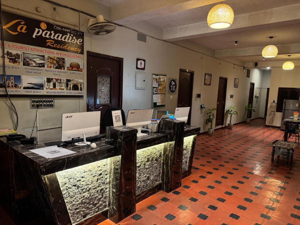 a restaurant with a counter with computers on it at La Paradise Residency - TIE Hotels in Pondicherry