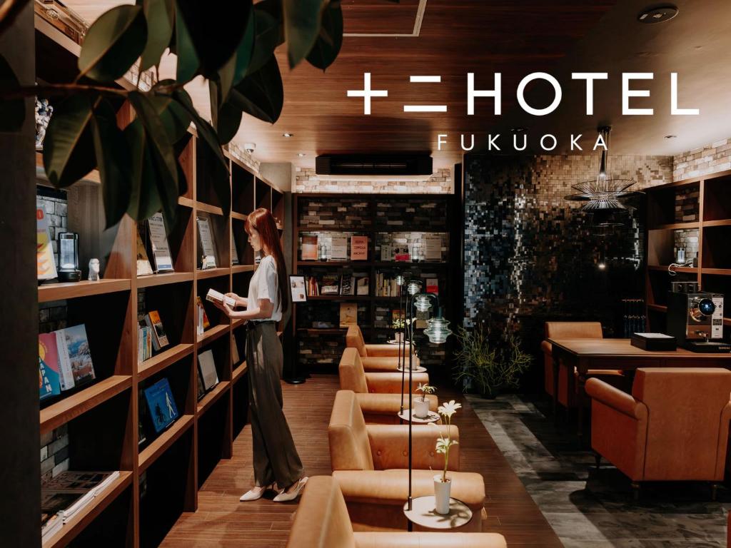 Eine Frau steht in der Hotellobby in der Unterkunft 十二ホテル -福岡空港- in Fukuoka