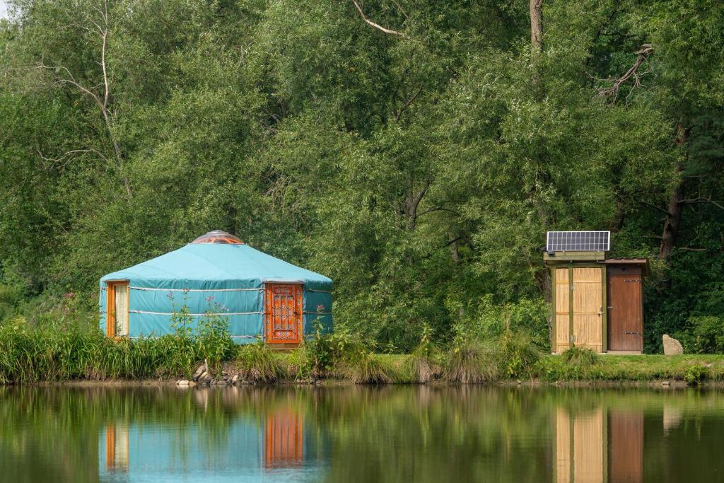 a blue dome building next to a body of water at Jurta na Jitrech in Tábor