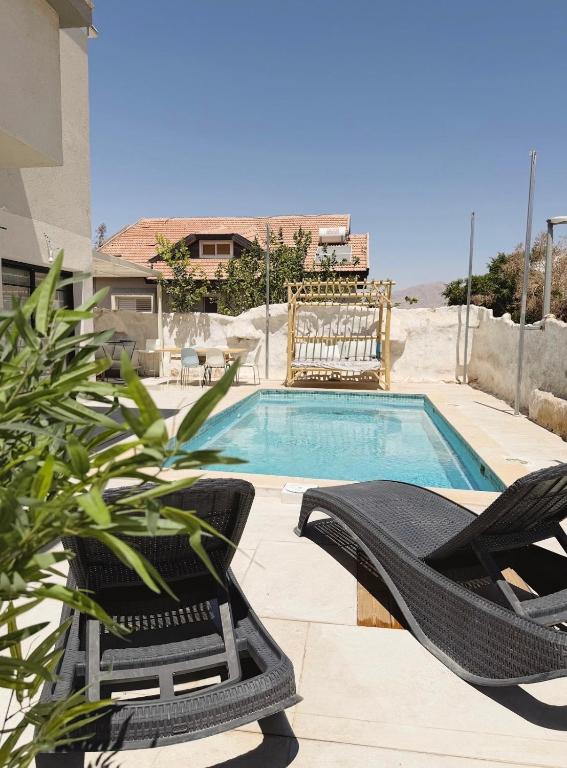 a swimming pool with two lounge chairs next to it at Villa Sea House in Eilat