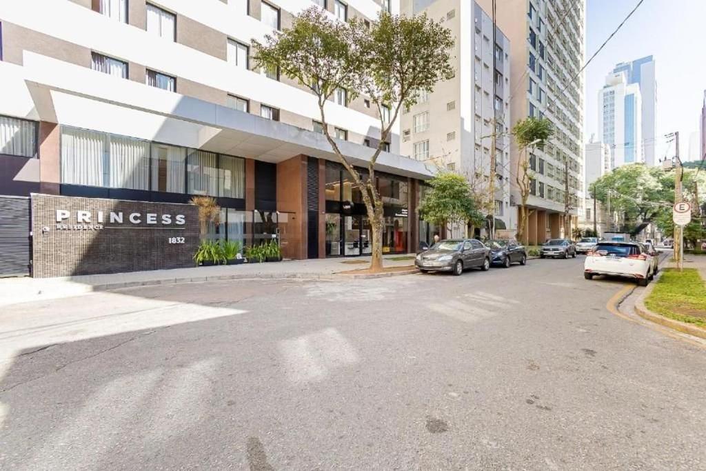 a street with cars parked in front of a building at Apto confortável Centro/Batel in Curitiba