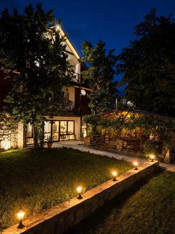 a house with lights in the yard at night at Hotel Chubu in Mestia