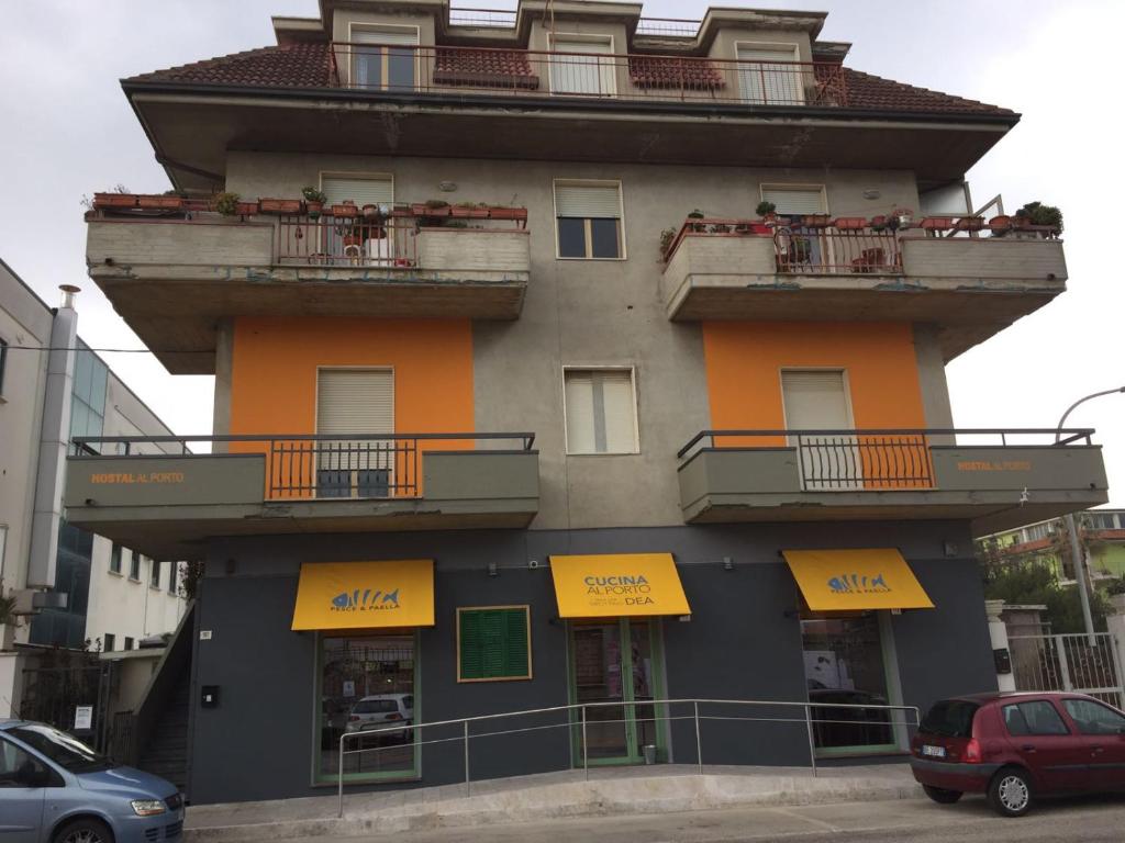 wysoki budynek z żółtymi znakami w obiekcie Hostal Al Porto w mieście San Benedetto del Tronto