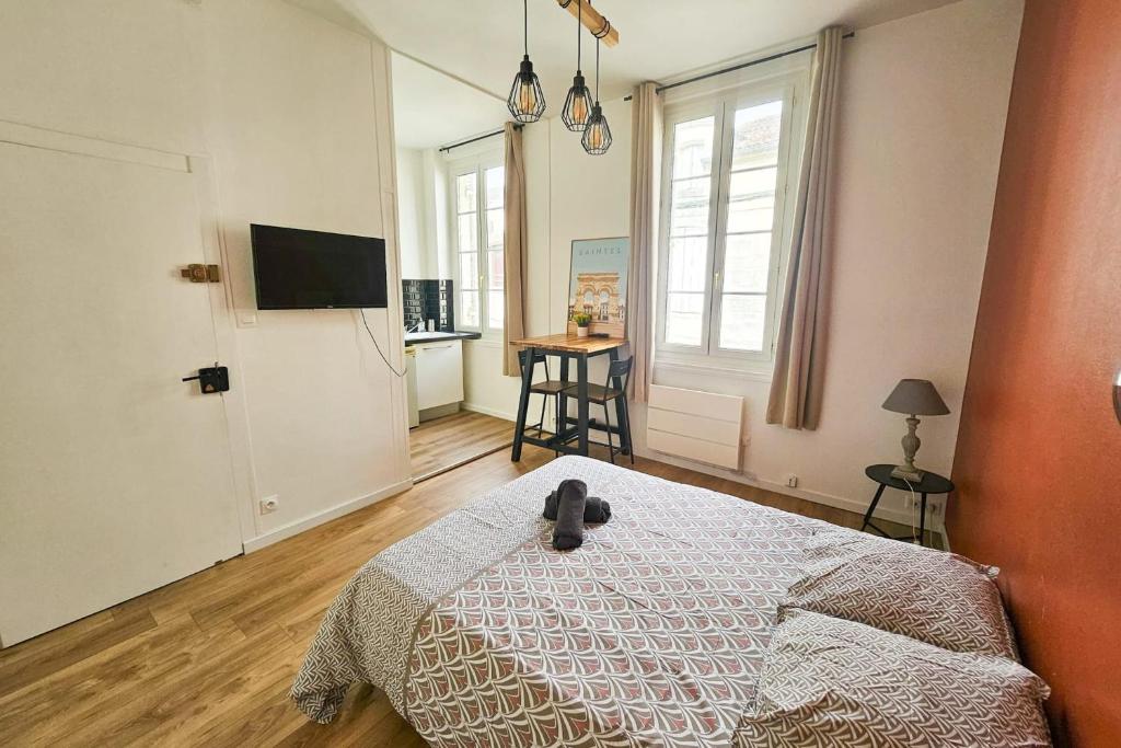 a bedroom with a bed with a teddy bear on it at "Les Arches 2" City Center Studio in Saintes