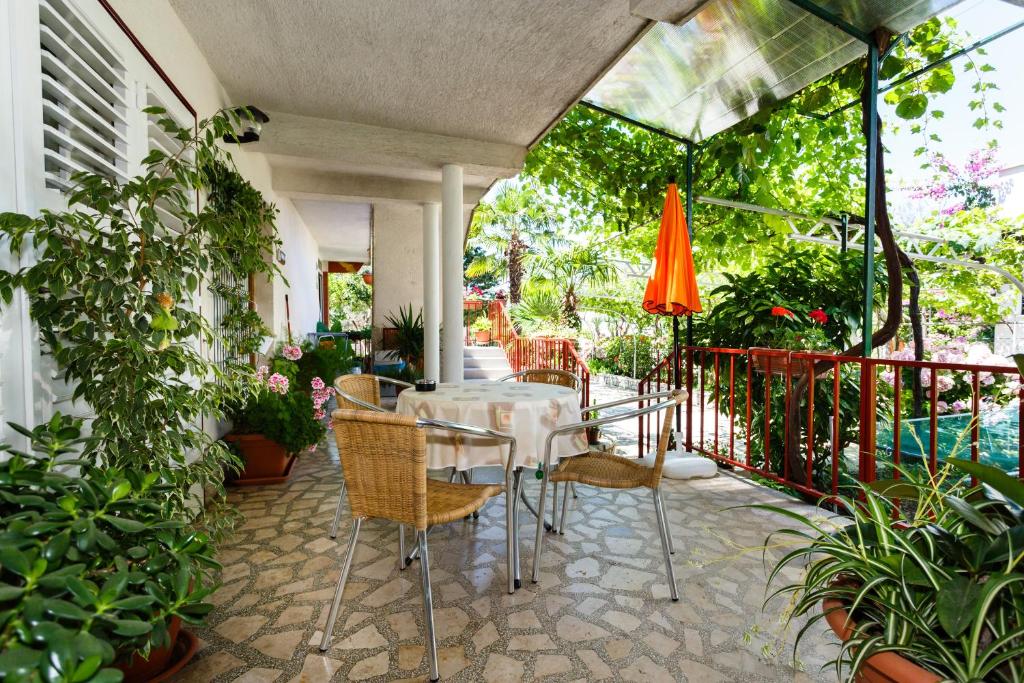 a table and chairs on a patio with plants at Apartments Lovorik in Krk