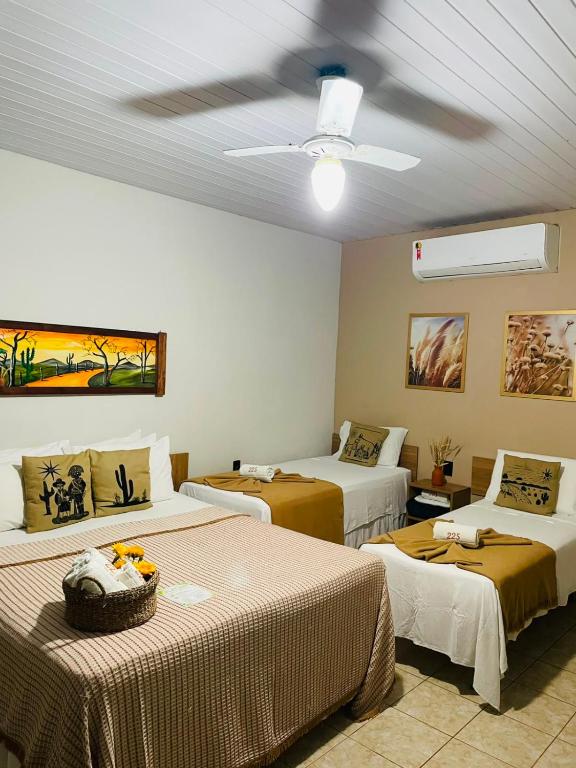 a bedroom with two beds and a ceiling fan at Apt Flat 225 Condomínio Pedra do Rodeadouro in Bonito