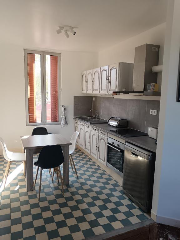 a kitchen with a table and a table and chairs at le bégare 