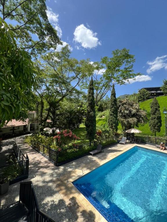 a swimming pool in a yard with trees and bushes at Selva del Rio San Jeronimo in San Jerónimo