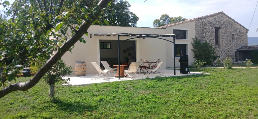 a house with a patio and a table and chairs at Gite des Egadillias climatisé in Marsanne