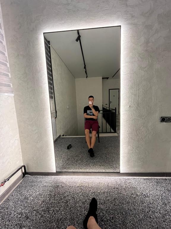 a man sitting in a chair in front of a mirror at Hostel in Talas
