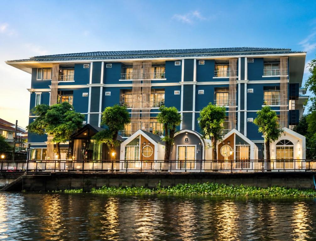 a blue building next to a river at Grace Riverfront Villa Near Suvarnabhumi Airport in Lat Krabang