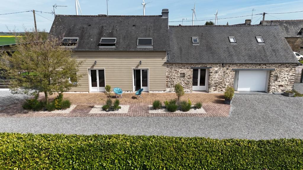 a house with two blue chairs in front of it at Le brin d'air Mayennais in Saint-Julien-du-Terroux
