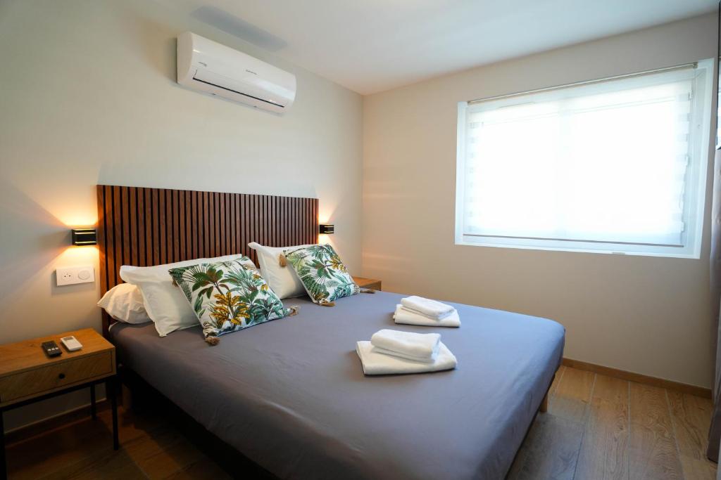 a bedroom with a bed with towels on it at T2 Les Suites du Roubion in Montélimar