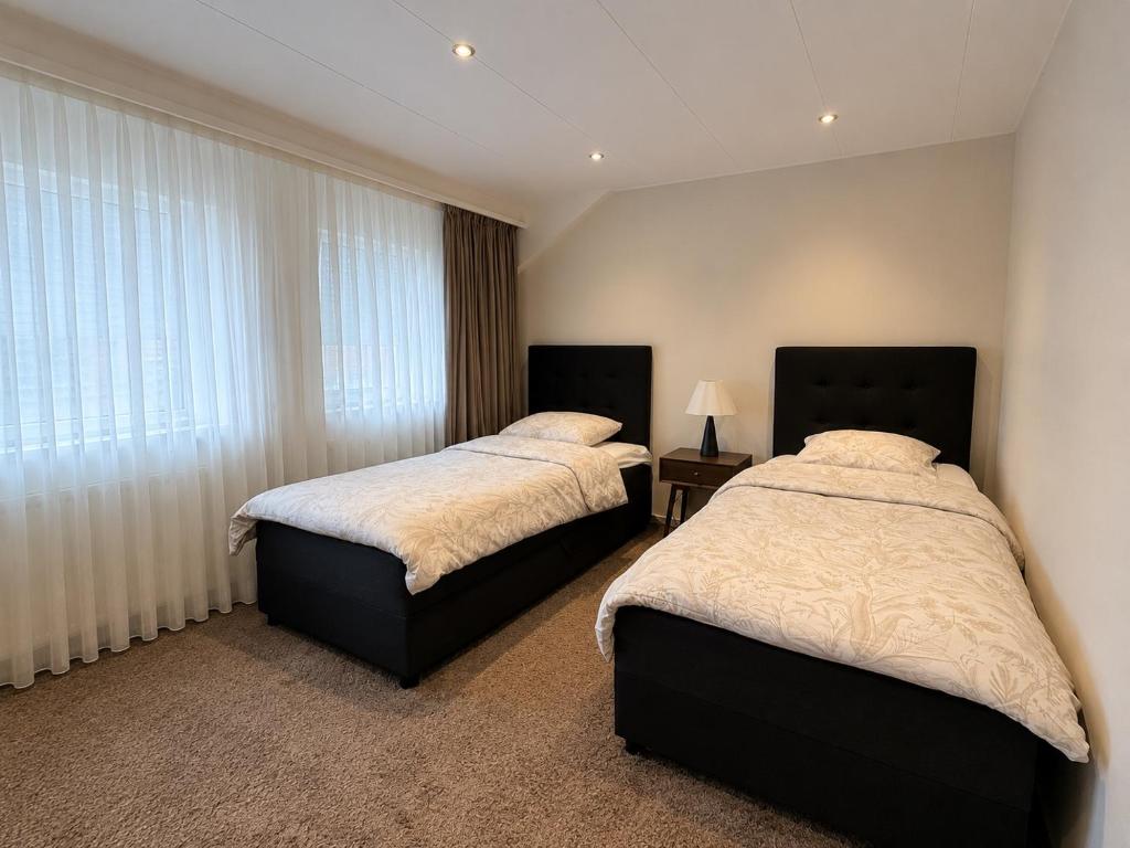 a bedroom with two beds and a window at LUXURY Home Axel in Axel