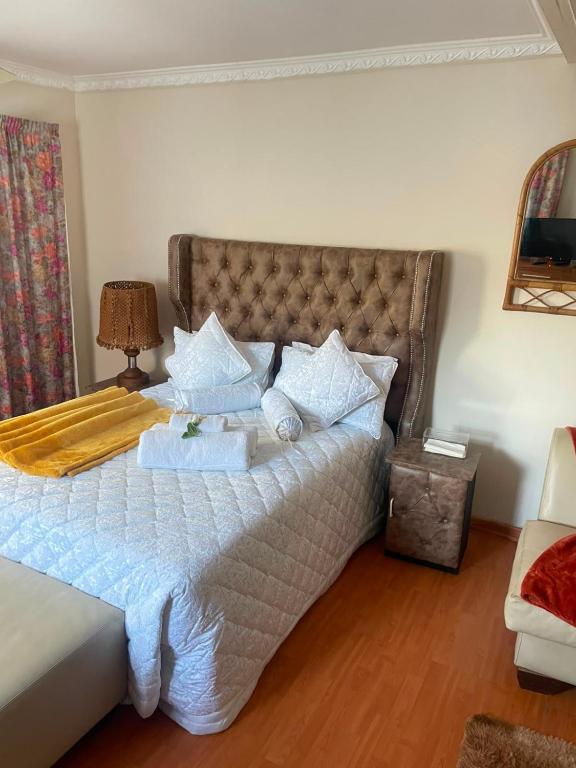 a bedroom with a large bed with white sheets and pillows at Executive B & B in Beacon Bay