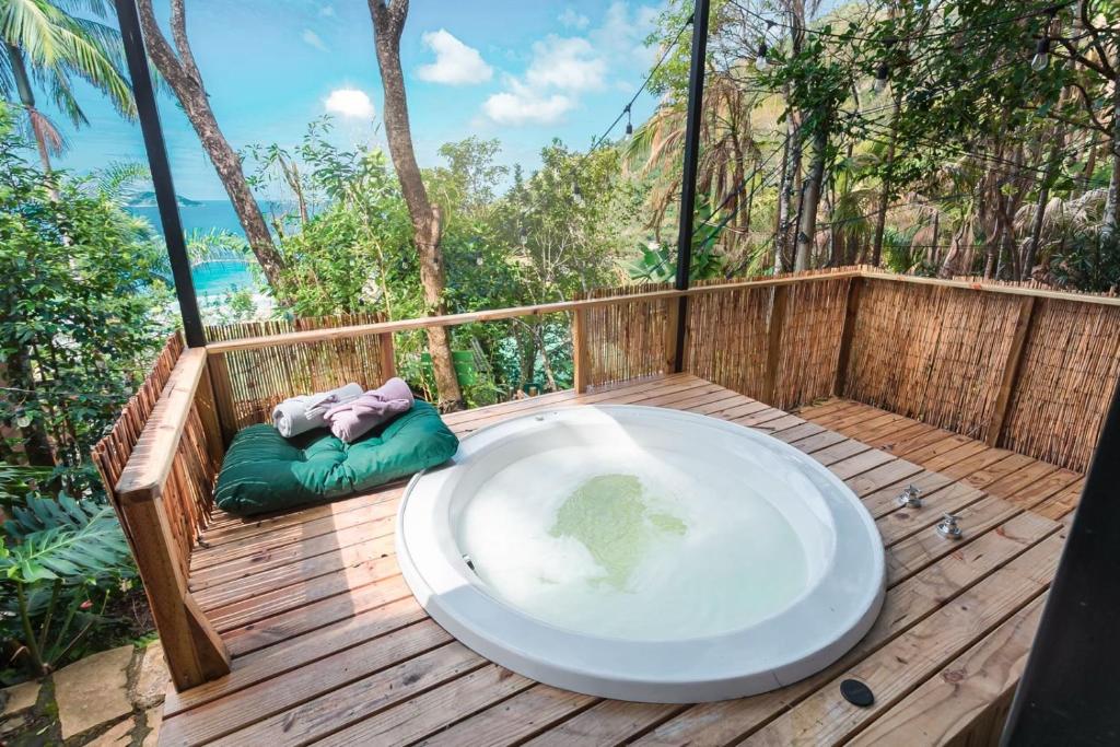 a bath tub sitting on a wooden deck at Chalé Sattva - Vista Mar e banheira de Hidromassagem quente - Florianópolis - SC - BR in Florianópolis