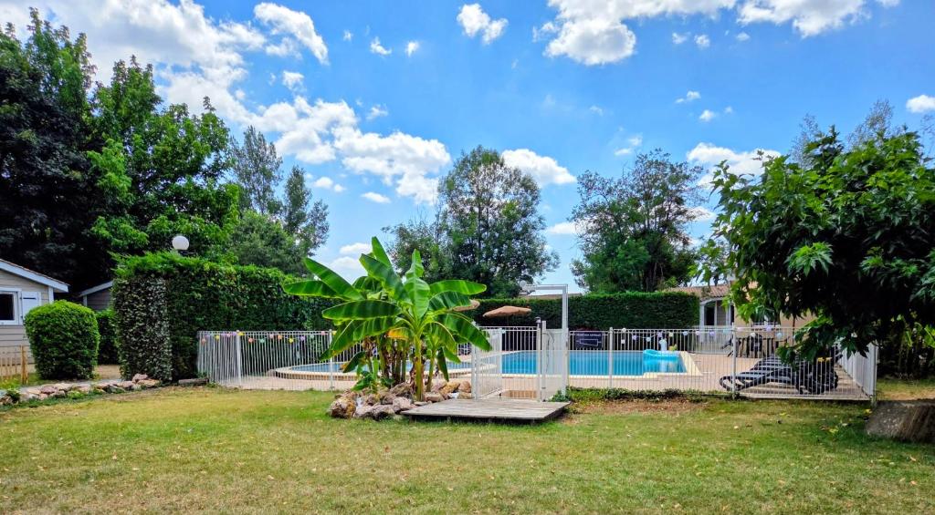 a yard with a fence and a swimming pool at Chalet tout confort in Rivières