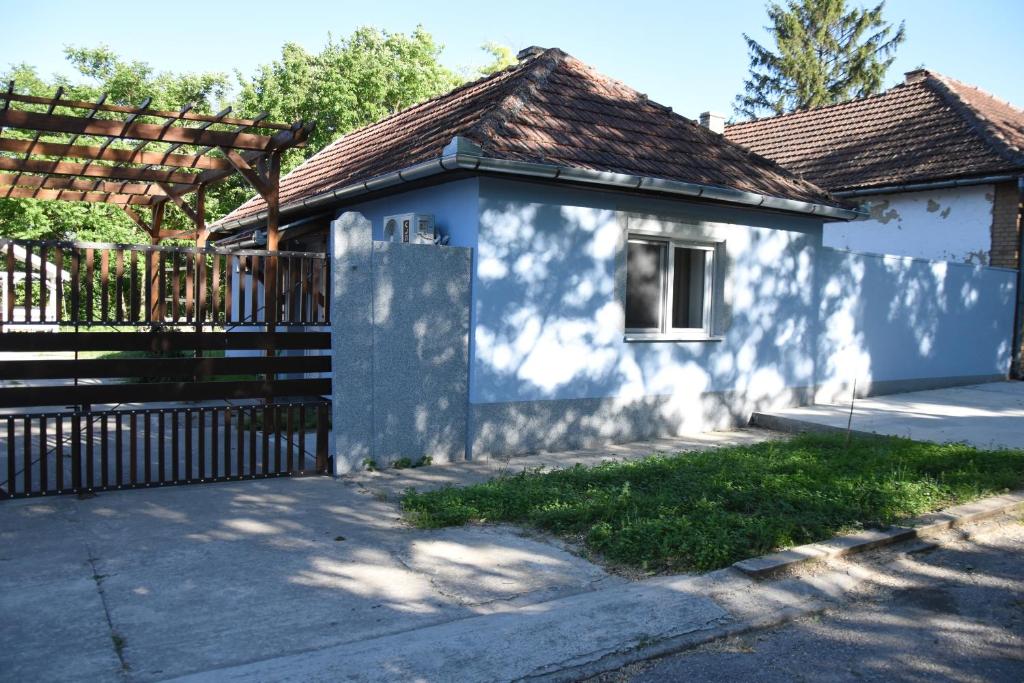 a white house with a gate and a fence at Ana apartmani in Pačir