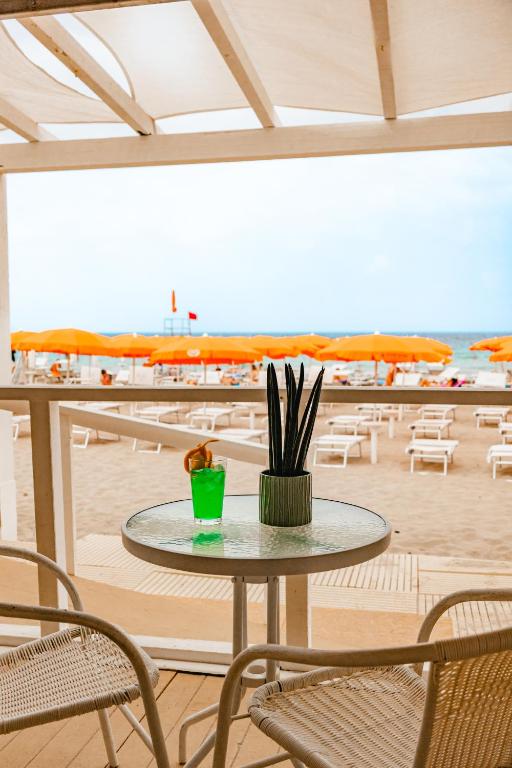 マルサラにあるDelfino Beach - CDSHotelsのビーチのある部屋のテーブルと椅子