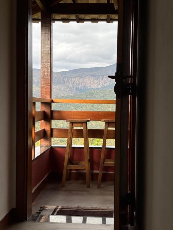 a view from a room with a table and a window at Vila Literária Tabuleiro in Conceição do Mato Dentro