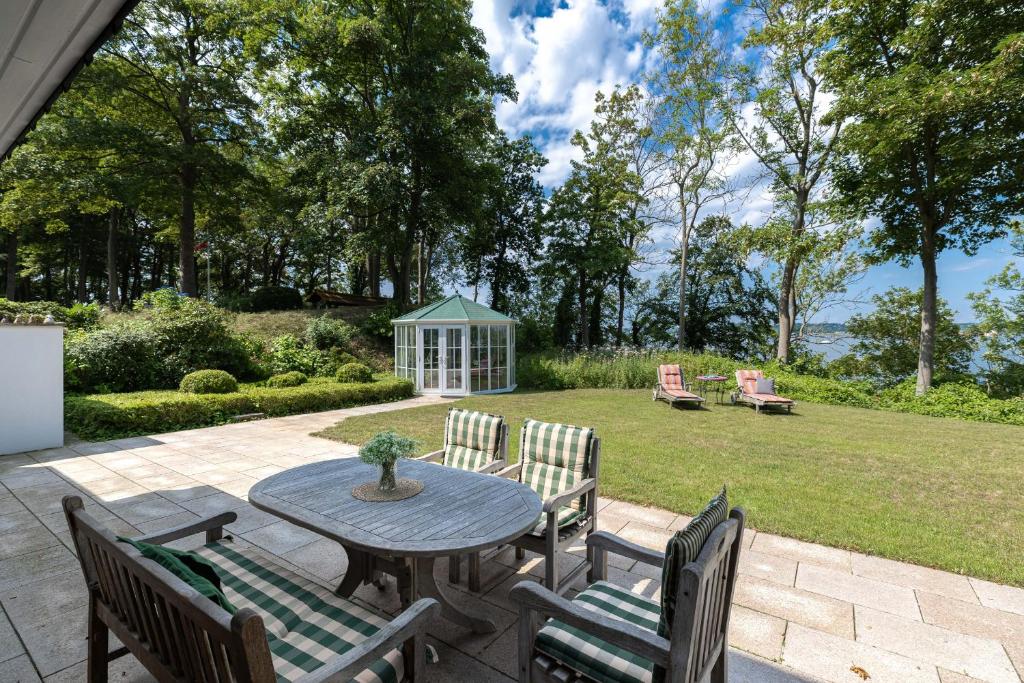 a patio with a table and chairs and a yard at Hohrott 17 Villa Bellevue I in Heikendorf