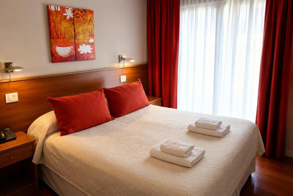 a bedroom with a bed with two towels on it at Hotel Benevento in La Plata