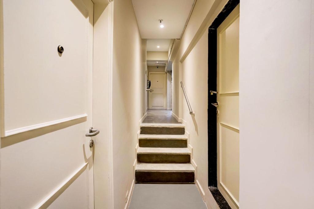 a hallway with stairs leading up to a door at Hotel O Siba Inn in Mumbai