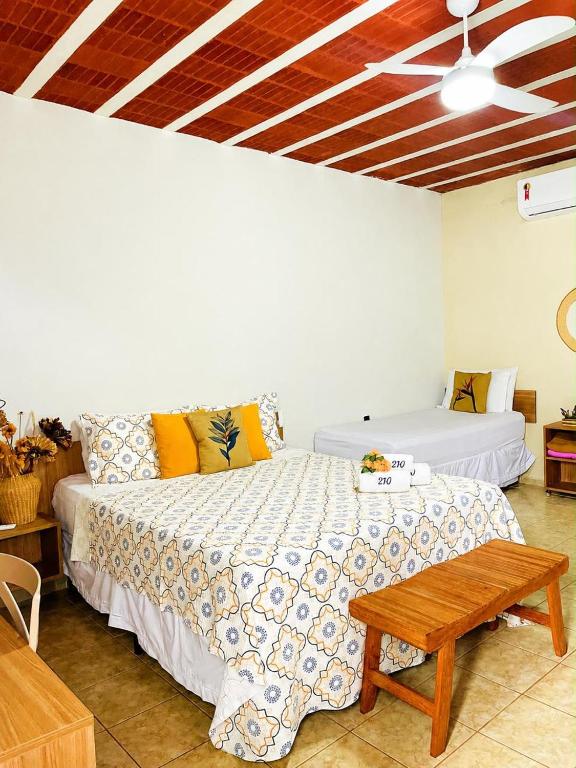 a bedroom with a bed and a table and a ceiling at Apt Flat 210 Condomínio Pedra do Rodeadouro in Bonito