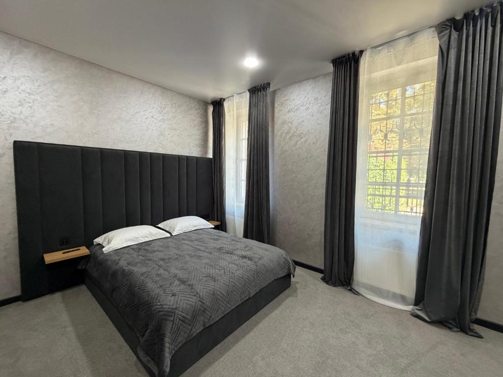 a bedroom with a large bed and a large window at U Dominicana in Kamianets-Podilskyi