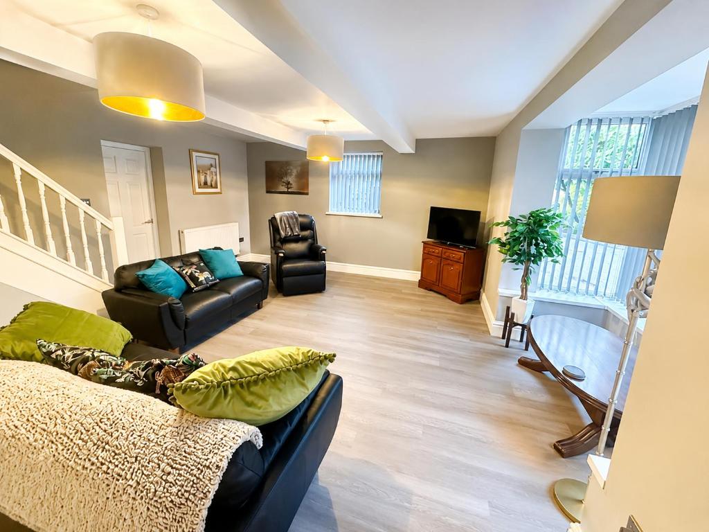 a living room with a couch and a chair at Rose Cottage by Sasco in Blackpool