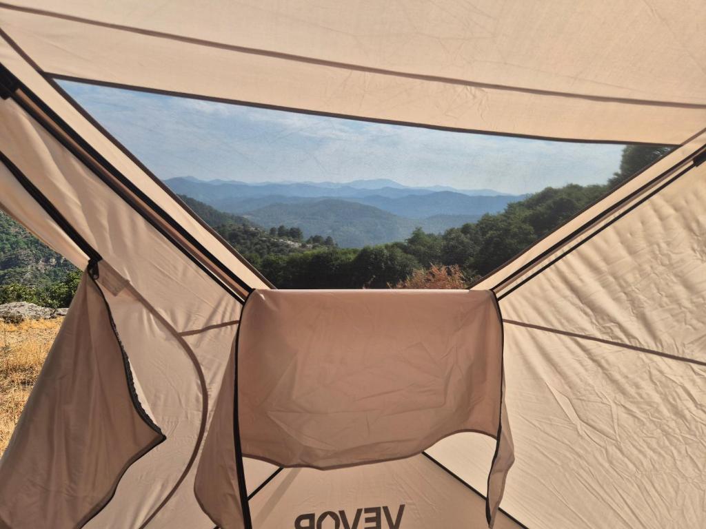 a chair in a tent with a view of the mountains at Yourte in Saint-Germain-de-Calberte