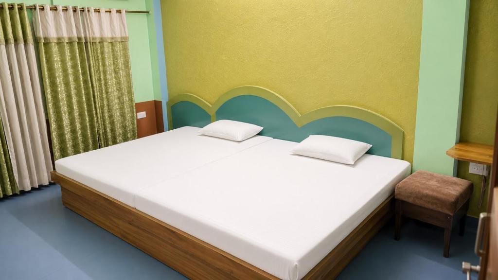 a bedroom with a large bed and a chair at new crown hotel in Indore