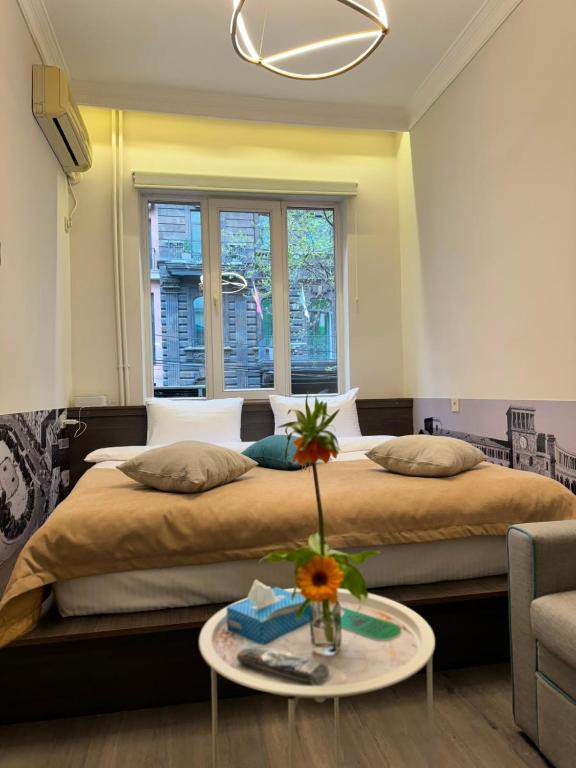 ein Schlafzimmer mit einem großen Bett und einem Tisch in der Unterkunft Skypiea Hotel in Yerevan