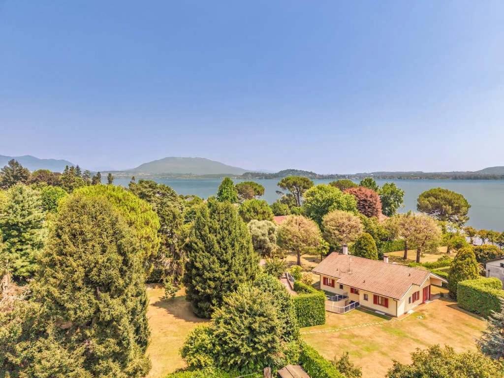 an aerial view of a house with trees and a lake at Large lakeside villa in Lesa