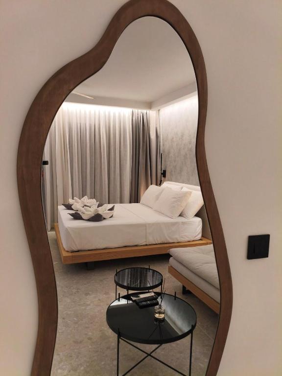 a bedroom with a bed and a large mirror at Odyssia Beach Hotel in Rethymno
