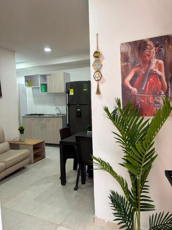 a living room with a painting of a woman playing a violin at Edificio Villa Linda Urb El Parque in Barranquilla