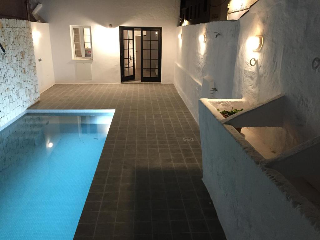 una piscina en una habitación con un edificio en Cas Conco, en Es Mercadal