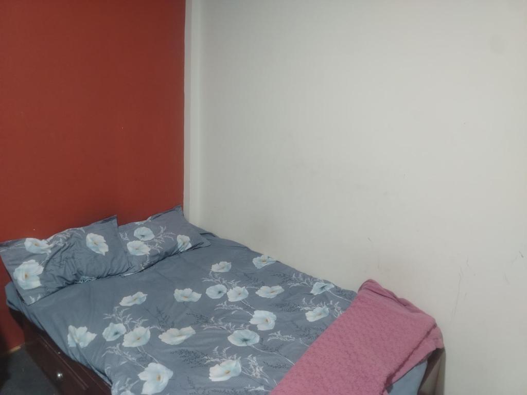 a bed with a blue comforter with flowers on it at Gupta House in Katmandu International